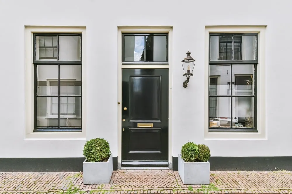 A natural wood front door on a brick building facade